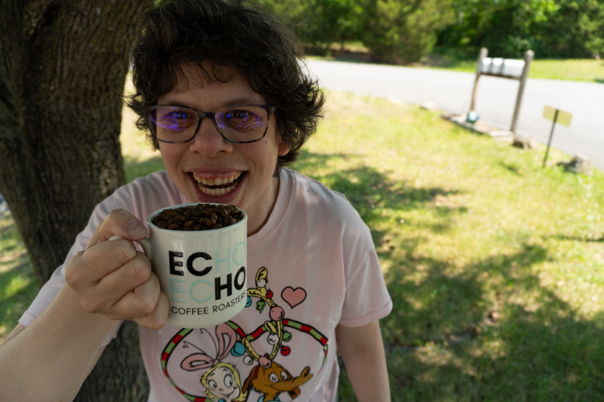 An ECHO team member smiling with a mug full of roasted beans